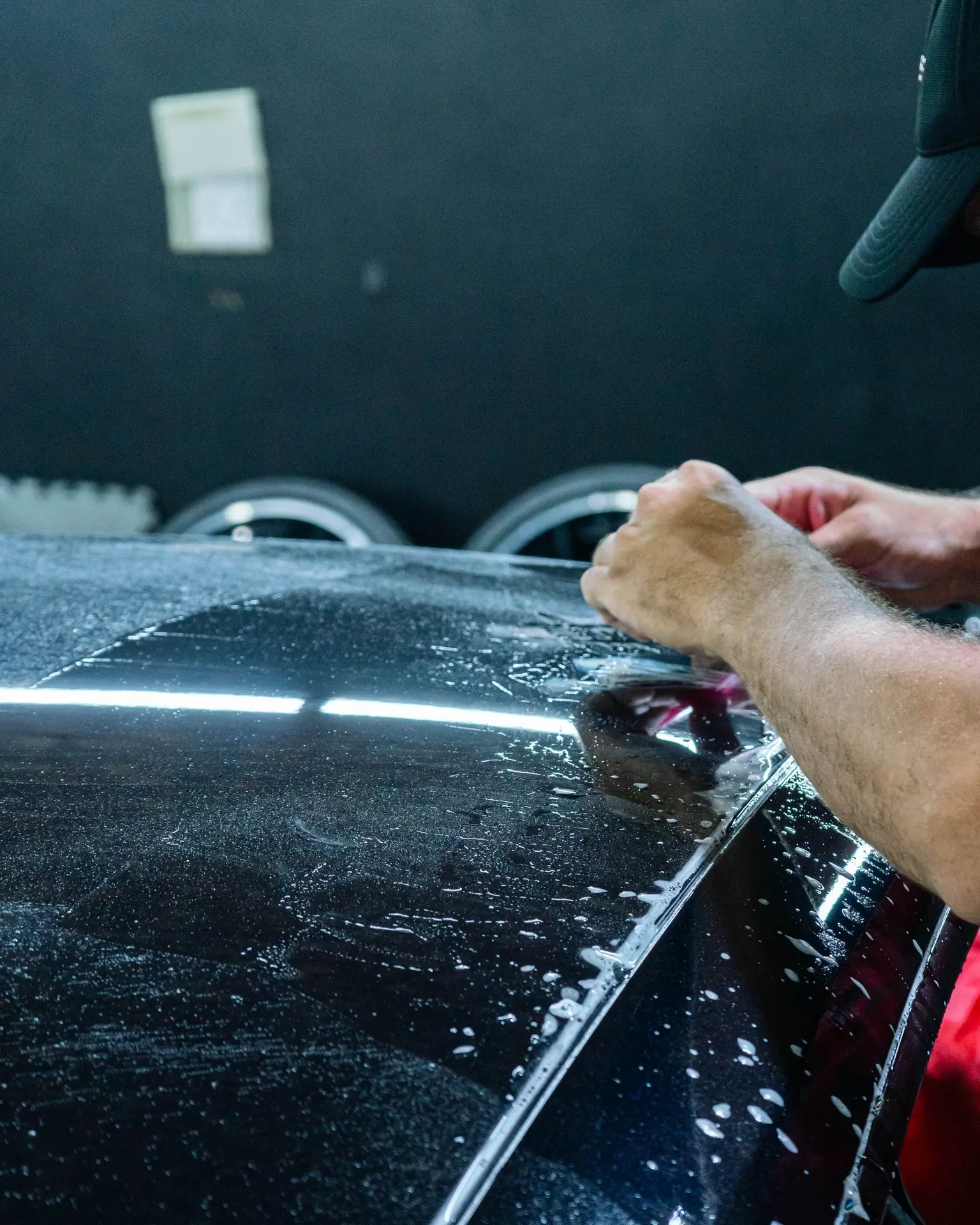Close-up of paint protection film edge on a vehicle panel, showing optical clarity of installed PPF